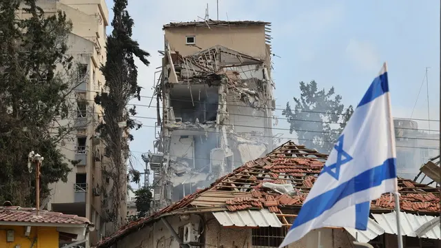 epa12176678 Israeli rescue teams work at the site of a damaged residential area after Iranian ballistic missiles hit Rehovot, central Israel, 15 June 2025. Iran launched a barrage of ballistic missiles at Israel overnight in retaliation for Israeli airstrikes on Iranian targets. Magen David Adom (MDA), Israel's national emergency services, reported at least six killed and dozens injured, including two in critical condition. EPA/ABIR SULTAN