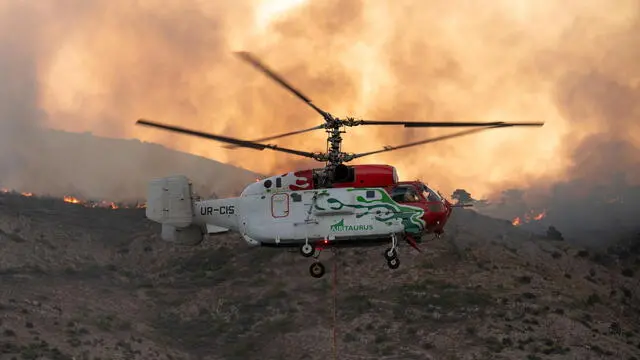 epa12193964 A firefighting helicopter during firefighting operations on Chios Island, Greece, 24 June 2025. Minister of Climate Crisis and Civil Protection Yannis Kefalogiannis visited Chios amid five separate wildfires. He warned that the simultaneous fires in different parts of the island suggest possible organized criminal activity and are unlikely to be accidental. EPA/KOSTAS KOURGIAS
