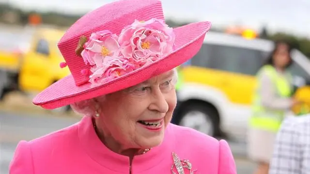 epa02980846 In matching pink hat and topcoat Britain's Queen Elizabeth II arrives with a smile at Perth International airport 26 October 2011 to attend the Commonwealth Heads of Government Summit as part of their 10 day visit to Australia. EPA/POOL POOL