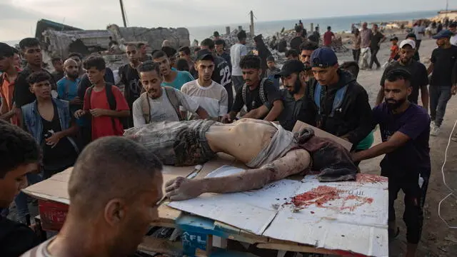 epa12191524 GRAPHIC CONTENT - Palestinians carry the body of a man killed during Israeli army fire while trying to collect food parcels, west of Jabalia, northern Gaza Strip, 22 June 2025. More than 55,700 Palestinians have been killed in the Gaza Strip, according to the Palestinian Ministry of Health, since Israel launched a military campaign in the strip in response to a cross-border attack led by the Palestinian militant group Hamas on 07 October 2023. EPA/HAITHAM IMAD -- ATTENTION EDITORS: GRAPHIC CONTENT
