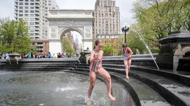 epa09166136 Children play in a fountain in Washington Square Park as temperatures reached near 76 degrees Fahrenheit (24 degrees Celsius) in New York, New York, USA, 28 April 2021. EPA/JUSTIN LANE