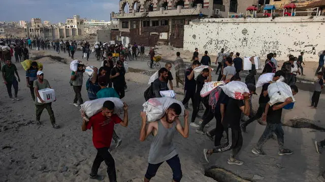epa12191496 Displaced Palestinians carry relief packages along Rashid Street, west of Jabalia, 22 June 2025, after humanitarian aid trucks entered the northern Gaza Strip through the Israeli-controlled Zikim crossing, northwest of Gaza City. More than 55,700 Palestinians have been killed in the Gaza Strip, according to the Palestinian Ministry of Health, since Israel launched a military campaign in the strip in response to a cross-border attack led by the Palestinian militant group Hamas on 07 October 2023. EPA/HAITHAM IMAD