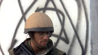 JER27 - 20001013 - JERUSALEM, - : An Israeli soldier takes cover behind a wall painted with the Star of David in the Kalandiya Arab Eeast Jerusalem refugee camp 13 October 2000 during clashes that erupted after Palestinians were prevented from entering the al-Aqsa mosque compound for Friday noon prayers. One Palestinian was killed and almost 100 wounded in scattered clashes in the West Bank and Gaza, the day after Israel's bombing raids on Palestinian targets. EPA PHOTO AFP/ANDRE DURAND/pbz/lfb-ee