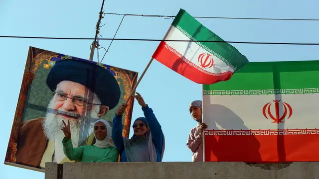 epa12197267 People stand between a picture of Iran's Supreme Leader, Ayatollah Ali Khamenei (L) and Iranian flags (R) during a celebration organized by Hezbollah in front of the Iranian Embassy in Beirut, Lebanon, 25 June 2025. Supporters of Hezbollah gathered in solidarity with the Iranian people, their political and military leadership, and Iran's Supreme Leader, Ayatollah Ali Khamenei, as they celebrated what they considered the victory of Iran against Israel and the US after US President Donald Trump announced a ceasefire between Israel and Iran. EPA/WAEL HAMZEH