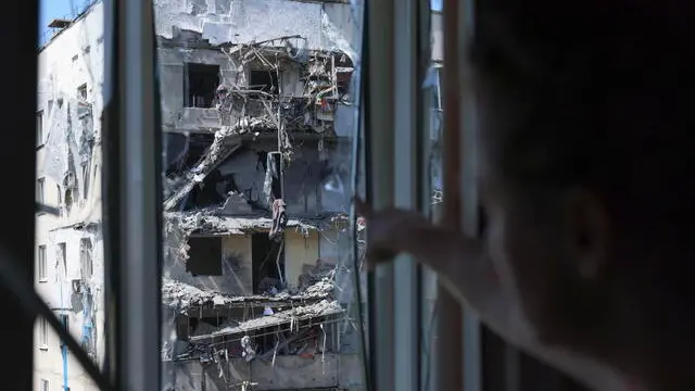 epa12046774 A local woman shows the view from her damaged flat at the site of a damaged high-rise residential building after a Russian missile strike in Zaporizhzhia, southeastern Ukraine, 22 April 2025, amid the Russian invasion. According to the State Emergency Service of Ukraine (SES), at least one woman was killed and 23 others were injured, including four children, after Russian shelling in Zaporizhzhia. EPA/OLEG MOVCHANIUK