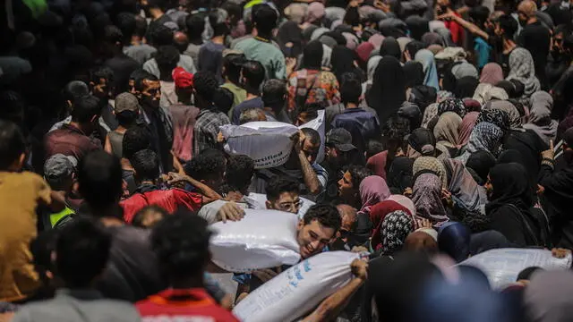 epa12198716 Displaced Palestinians wait to receive aid through the WFP after it successfully arrived at the organization’s warehouses in Gaza City, 26 June 2025. According to the UN half a million people, or one in five people in the Strip are facing starvation while the entire population of the Gaza Strip continues to face a critical risk of famine following 19 months of conflict, mass displacement and severe restrictions on humanitarian aid. EPA/MOHAMMED SABER