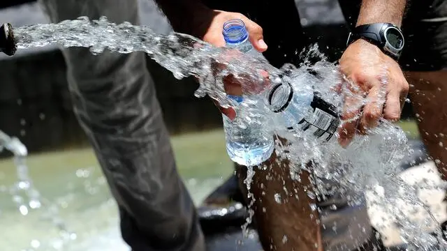 Un uomo riempie due bottigliette d'acqua da una fontanella, oggi 15 luglio 2010 a Roma. Si allarga l'allarme rosso afa per le citta' italiane. Oggi il numero delle citta' in allerta 3 (il massimo) salira' da sei a nove (Bolzano, Brescia, Genova, Firenze, Milano, Perugia, Roma, Torino e Trieste) mentre venerdi' 16 luglio saranno 19 (Bolzano, Bologna, Brescia, Campobasso, Civitavecchia, Firenze, Frosinone, Genova, Latina, Messina, Milano, Perugia, Rieti, Roma, Torino, Trieste, Venezia, Verona e Viterbo). Il picco del caldo e' previsto dalla Protezione Civile tra venerdi' e sabato. Il ministero della Salute ha attivato il numero verde 1500. ANSA/CLAUDIO ONORATI/on