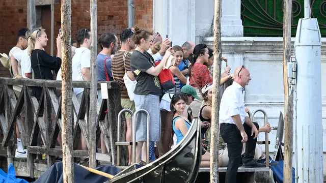 People crowded on a pier overlooking the Aman Hotel in Venice, where Amazon billionaire Jeff Bezos is accommodated, Venice, Italy, 26 June 2025. ANSA/DANIEL DAL ZENNARO