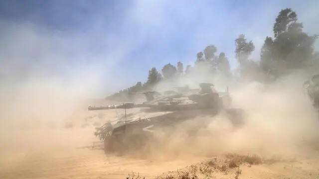 epa12118907 Israeli Merkava tanks maneuver towards the southern Gaza Strip border near Khan Yunis, seen from southern Israel, 20 May 2025. Israel's military continued to strike targets across the Gaza Strip as part of its 'Gideon's Chariots' operation. EPA/ATEF SAFADI