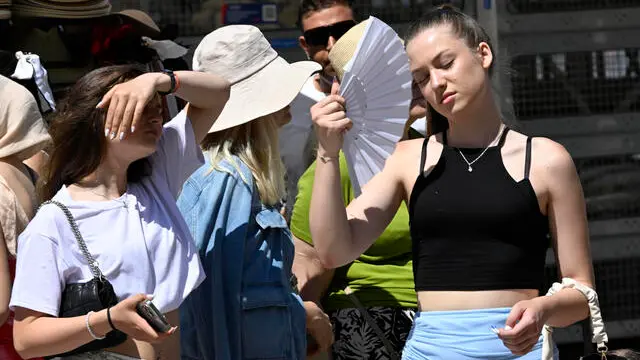 Una turista cerca refrigerio dal caldo utilizzando un ventaglio, Venezia, 28 giugno 2025. Caldo ad oltranza con 40°C all'ombra da Nord a Sud: questo è il nuovo scenario del clima scaldato ulteriormente dalla persistenza dell'Anticiclone africano sull'Italia. La prossima settimana sarà caratterizzata da un caldo eccezionale. ANSA/DANIEL DAL ZENNARO