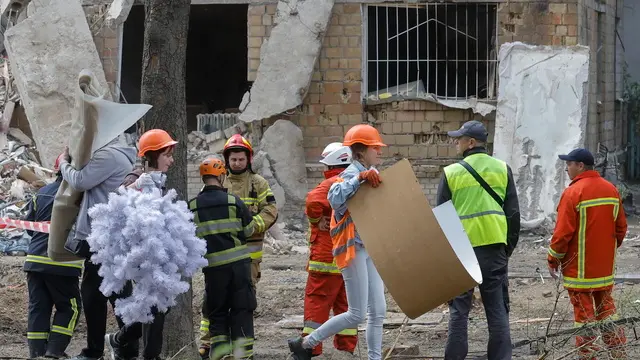 epa12195000 Ukrainian volunteers work to help people at the site of a rocket strike on a five-storey residential building on 23 June, in Kyiv, Ukraine, 24 June 2025, amid the ongoing Russian invasion. Nine people died and more than 38 were injured in Kyiv after Russia launched a large-scale combined attack with at least 16 missiles and 352 drones across Ukraine on 23 June 2025, according to the State Emergency Service. EPA/SERGEY DOLZHENKO