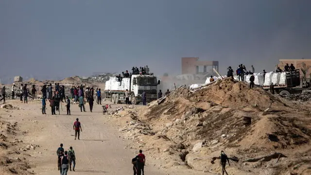 epa12197278 Palestinians from the clans secure aid trucks after they were allowed to enter humanitarian organizations in the Gaza Strip by the Israeli side, in the Zikim area west of Beit Lahia, northern Gaza Strip, 25 June 2025. EPA/HAITHAM IMAD