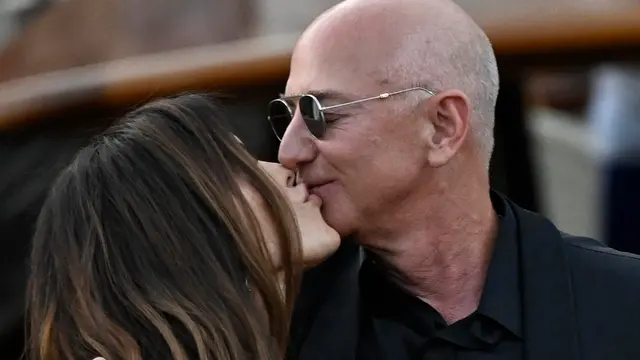 epa12203526 Lauren Sanchez Bezos kisses Jeff Bezos as they depart from the Aman hotel during wedding celebrations the day after their wedding in Venice, Italy, 28 June 2025. EPA/DANIEL DAL ZENNARO