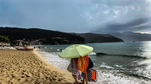 La pioggia allontana i bagnanti dalla spiaggia della Biodola a Portoferraio, isola d'Elba, 18 agosto 2024. ANSA/LUCIANO DEL CASTILLO