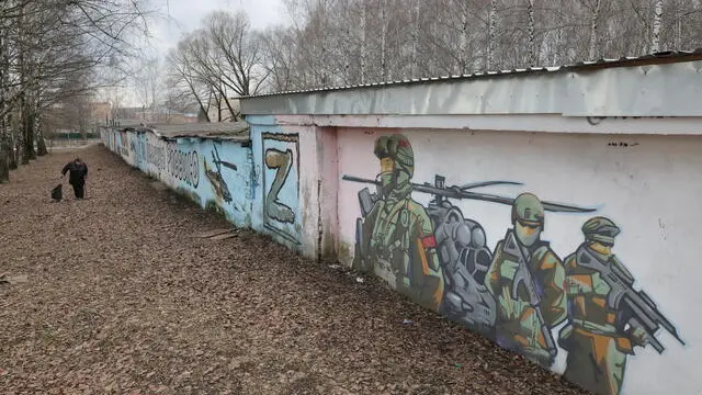 epa11963613 A woman walks in front of a graffiti showing Russian soldiers, created by Russian street artist Ivan Pimkin in support of the Russian Armed Forces, in the town of Pavlovsky Posad, Moscow region, Russia, 14 March 2025. EPA/MAXIM SHIPENKOV