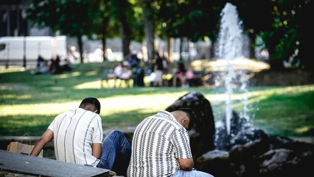 Due uomini in cerca di refrigerio nei giardini di piazza Carlo Felice per combattere le alte temperature dovute all'ondata di caldo estivo. Torino 28 giugno 2025 ANSA/TINO ROMANO