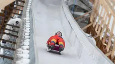 Atleti provano la pista durante la cerimonia di inaugurazione della pre-omologazione dello Sliding Centre utilizzato per le prossime Olimpiadi Invernali di Milano-Cortina 2026 a Cortina d’Ampezzo, 25 marzo 2025. ANSA/ANDREA SOLERO