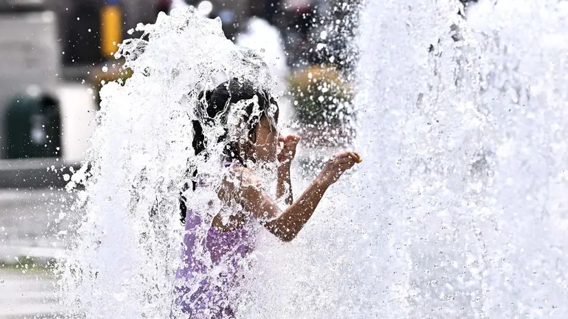 Bambini e turisti cercano refrigerio dalla calura africana, dalla fontana di piazza De Ferrari. Genova, 02 luglio 2025. ANSA/LUCA ZENNARO