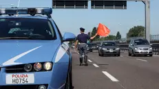 Una pattuglia della Polizia stradale controlla lil traffico sull'autostrada A14 nei pressi di Bologna. Il bollino nero annunciato per l'esodo di fine luglio nel nodo stradale di Bologna e sull'A14 ha un colore sbiadito. Fin dalla prima mattina il traffico è stato intenso ma scorrevole. Non sono mancati i rallentamenti, tanto che verso le 11 il tempo di percorrenza previsto tra Bologna San Lazzaro e Rimini era di 120-130 minuti (normalmente basta la metà).GIORGIO BENVENUTI