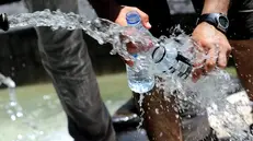 Un uomo riempie due bottigliette d'acqua da una fontanella, oggi 15 luglio 2010 a Roma. Si allarga l'allarme rosso afa per le citta' italiane. Oggi il numero delle citta' in allerta 3 (il massimo) salira' da sei a nove (Bolzano, Brescia, Genova, Firenze, Milano, Perugia, Roma, Torino e Trieste) mentre venerdi' 16 luglio saranno 19 (Bolzano, Bologna, Brescia, Campobasso, Civitavecchia, Firenze, Frosinone, Genova, Latina, Messina, Milano, Perugia, Rieti, Roma, Torino, Trieste, Venezia, Verona e Viterbo). Il picco del caldo e' previsto dalla Protezione Civile tra venerdi' e sabato. Il ministero della Salute ha attivato il numero verde 1500. ANSA/CLAUDIO ONORATI/on