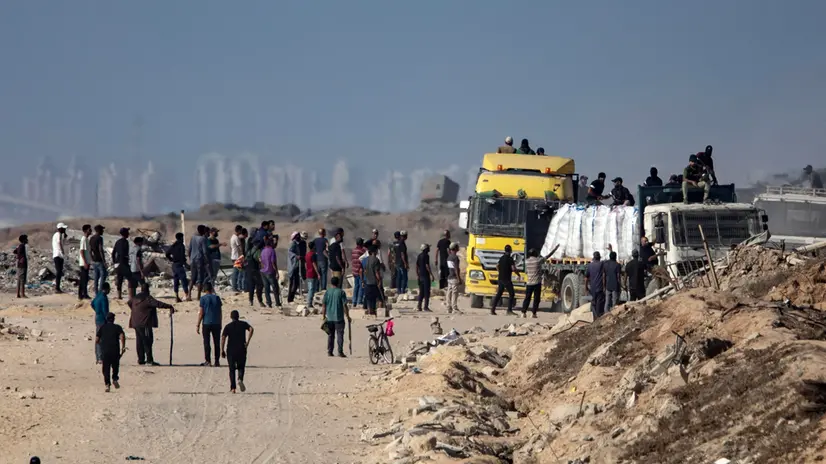 epa12197292 Palestinians from the clans secure aid trucks after they were allowed to enter humanitarian organizations in the Gaza Strip by the Israeli side, in the Zikim area west of Beit Lahia, northern Gaza Strip, 25 June 2025. EPA/HAITHAM IMAD