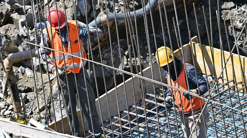 Operai edili al lavoro sotto il sole in un cantiere. Genova, 31 luglio 2023. ANSA/LUCA ZENNARO
