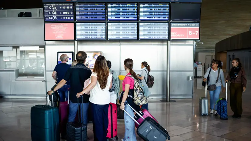 epa12212175 Passengers look at flight information boards inside Roissy-Charles de Gaulle Airport during a French air traffic controllers' strike, in Roissy-en-France outside Paris, France, 03 July 2025. The French UNSA-ICNA union has called for a two-day strike on 03 and 04 July over working conditions, causing travel disruption. EPA/YOAN VALAT