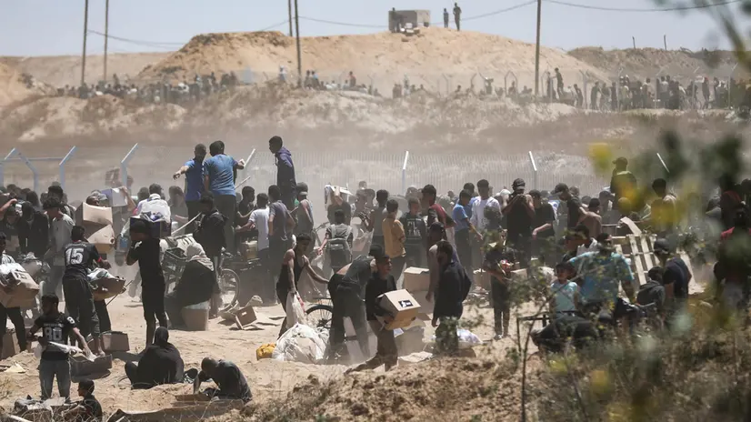epaselect epa12143208 Palestinians carry aid supplies received from the US-backed Gaza Humanitarian Foundation through an area known as the Netzarim Corridor, central Gaza Strip, 29 May 2025. According to the UN half a million people, or one in five people in the Strip are facing starvation while the entire population of the Gaza Strip continues to face a critical risk of famine following 19 months of conflict, mass displacement and severe restrictions on humanitarian aid. EPA/HAITHAM IMAD