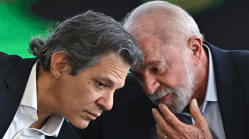 epa12208967 Brazilian President Luiz Inacio Lula da Silva (R) speaks with Finance Minister Fernando Haddad (L), during the launching ceremony of the 2025/2026 Safra Plan at the Planalto Palace in Brasilia, Brazil, 01 July 2025. Brazilian President Lula announced public credit lines totaling 516.2 billion reais (93.85 billion dollars) for the country's agricultural sector. EPA/ANDRE BORGES
