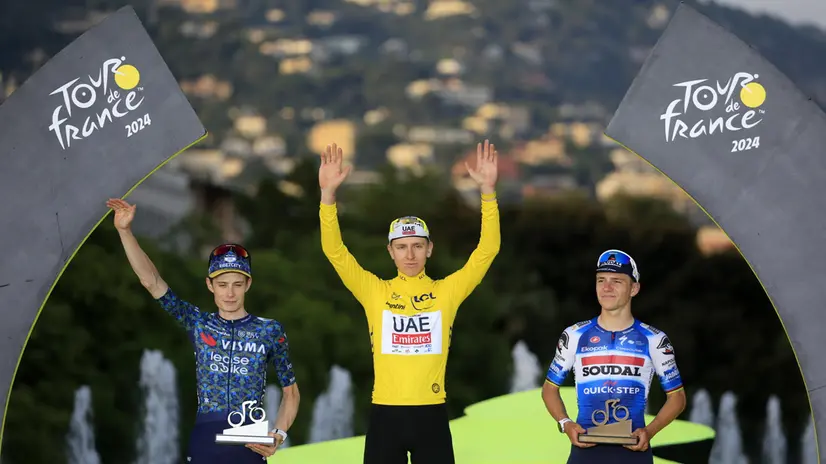 Il podio del tour 2024 con Tadej Pogacar in giallo tra Jonas Vingegaard e Remco Evenepoel - Foto Epa/Guillaume Horcajuelo