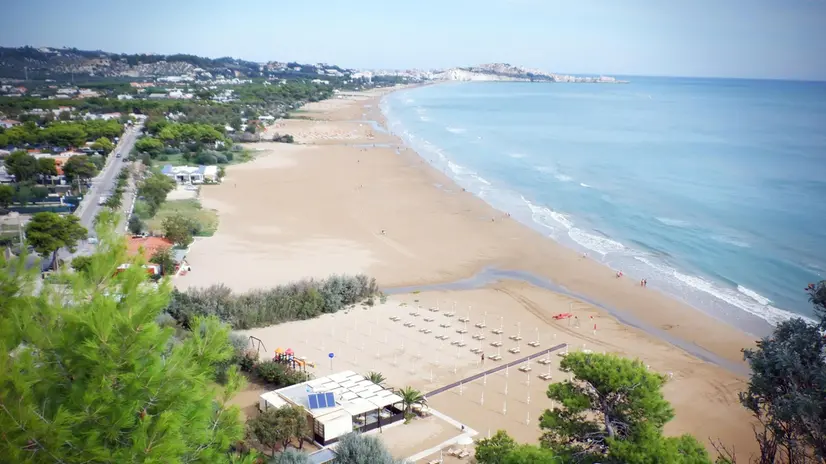 Veduta di Vieste con il promontorio del Gargano (Foggia), il paese e la spiaggia, in una foto d'archivio. ANSA / GIUSEPPE GIGLIA (mare, estate, belpaese, turismo, puglia, gargano, generiche)