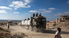 epa12197287 Palestinians from the clans secure aid trucks after they were allowed to enter humanitarian organizations in the Gaza Strip by the Israeli side, in the Zikim area west of Beit Lahia, northern Gaza Strip, 25 June 2025. EPA/HAITHAM IMAD