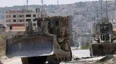 epa11458475 Israeli military bulldozers during an Israeli military operation in the West Bank city of Jenin, 05 July 2024. At least six people have been killed as a result of Israel's military operation in Jenin and its refugee camp, the Palestinian Ministry of Health said. The Israeli military stated that its forces were conducting 'counterterrorism activity' in the area of Jenin. EPA/ALAA BADARNEH