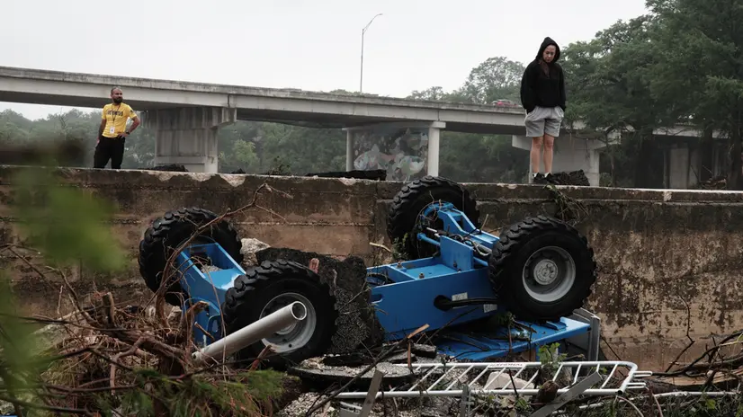epa12219269 People view a construction vehicle amongst flood debris in the Guadalupe River, in Kerrville, Texas, USA, 05 July 2025. Early 04 July, floodwaters swept through a summer camp and nearby homes, killing at least two dozen people, with dozens of campers still unaccounted for. EPA/DUSTIN SAFRANEK