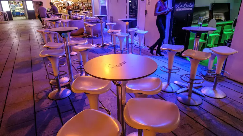 epa08612504 Clients have a drink in an almost empty pub shortly before it closes in Ibiza island, eastern Spain, early 19 August 2020. Nightclubs and pubs have to close at 1:00 AM and clients have to keep a social distance of 1.5 meters. Ibiza is one of the most popular destinations for foreign and local tourism. The restrictions imposed by authorities to contain the COVID-19 virus disease spreading are deeply affecting several businesses of the city. EPA/Sergio G. Canizares