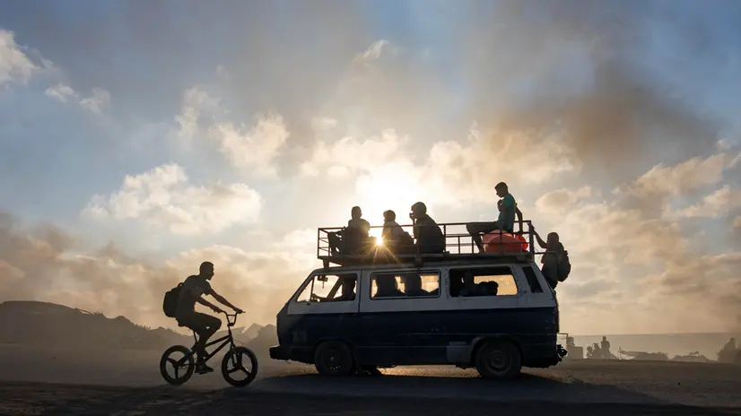 epa12213691 Palestinians head to gather to receive humanitarian aid to be delivered through the Netzarim Corridor in the central Gaza Strip, passing by a makeshift solar production point on Al-Rashid Street in western Gaza City, 03 July, 2025. EPA/HAITHAM IMAD