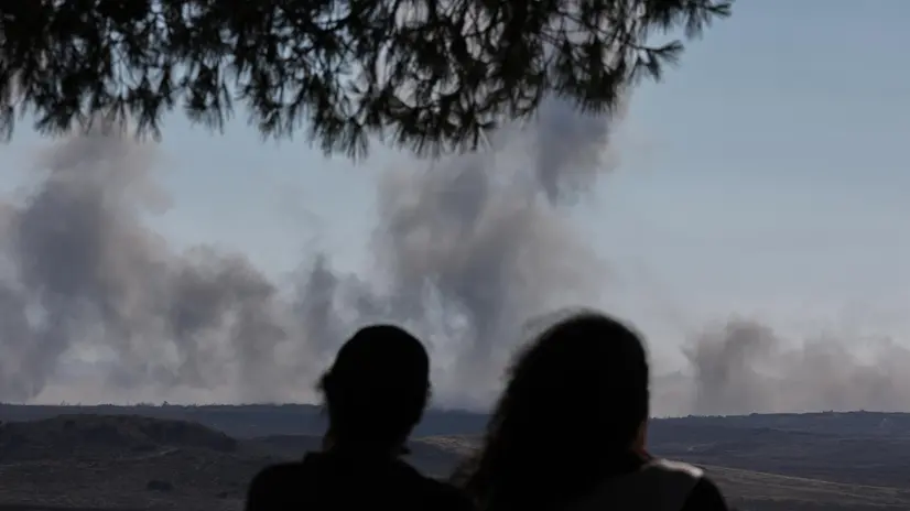epa12213106 Israelis watch smoke rise from north Gaza near Beit Hanoun as seen from the Israeli side of the border, 03 July 2025. EPA/ATEF SAFADI