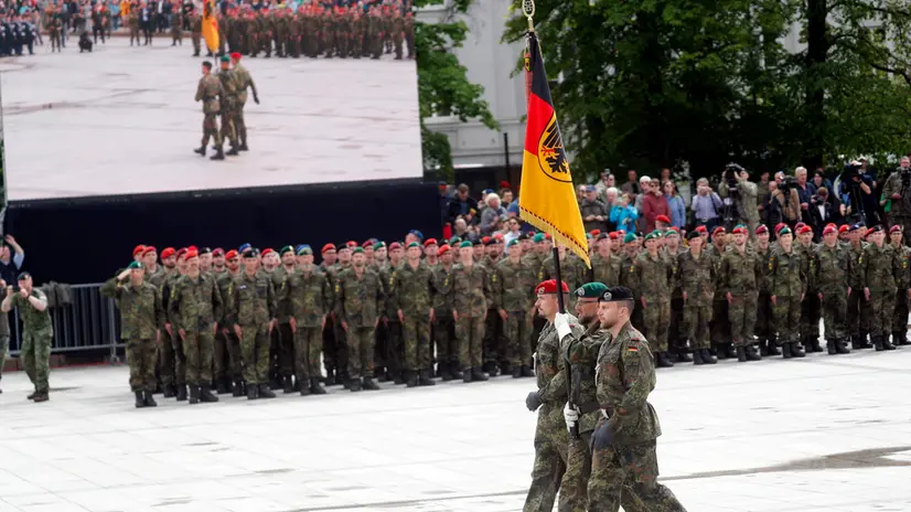 epa12125682 German army servicemen carry a Bundeswehr command flag during the inauguration of the German 45th Armoured Brigade 'Lithuania', at the Cathedral Square in Vilnius, Lithuania, 22 May 2025. The Brigade in Lithuania was activated on 01 April 2025, and will comprise around 5,000 military and civilian Bundeswehr personnel, with a full operational combat capability expected to be achieved by 2027. EPA/TOMS KALNINS