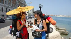 20092407_BARI_CALDO. Il caldo record ? arrivato anche in Puglia. Questa mattina la colonnina di mercurio ha segnato quasi 40 gradi. Nella foto turisti turchi cercano riparo dal sole. foto Ansa/Luca Turi