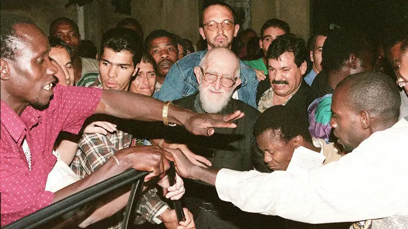 E23 - 20.08.96 - PARIGI - CRO: FRANCIA, PROSEGUE PROTESTA AFRICANI IN CHIESA PARIGI. L'Abbe Pierre (C) viene accompagnato alla sua auto da una folla di africani dopo aver visitato la chiesa di Saint-Bernard, occupata da circa 300 immigrati clandestini che protestano contro la mancata concessione del visto. Una decina di manifestanti sono giunti al 46mo giorno di digiuno per protestare contro la decisione delle autorita' francesi. DO THOMAS COEX/ANSA