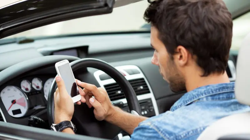 Persona che utilizza il cellulare alla guida
