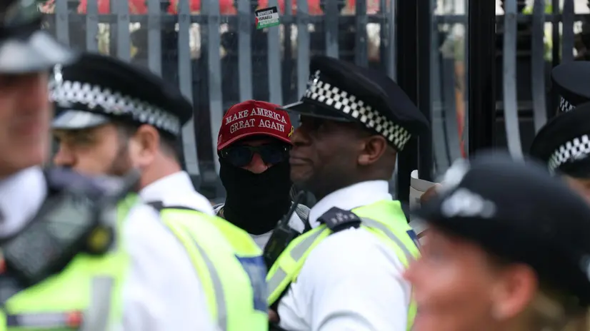 epa12192895 A person wearing a MAGA hat stands next to police officers during a demonstration in support of Palestine Action in Trafalgar Square, London, Britain, 23 June 2025. The British government has decided to ban Palestine Action following the vandalism of two planes at an RAF base, which would make it a criminal offence to belong to or support the group. EPA/NEIL HALL