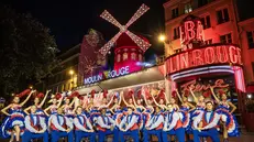 epa11461247 French Moulin Rouge venue dancers perform a French Can-Can dance outside Parisian famous Cabaret in Paris, France, 05 July 2024 as part of the inauguration of its new windmill blades. The windmill blades on the facade of the famous Moulin-Rouge cabaret broke off during the night of 25 April 2024. EPA/CHRISTOPHE PETIT TESSON