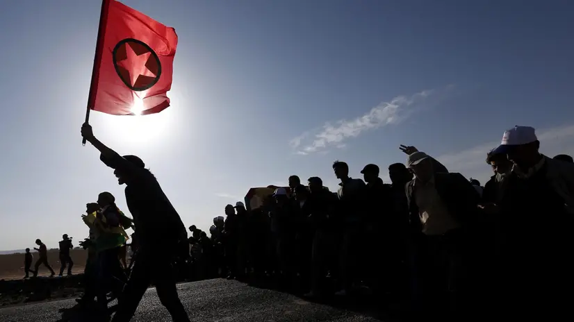epa04459616 A Kurd carries the flag of the Kurdish Kurdistan Workers' Party (PKK) during the funeral for female Kurdish fighters, killed in clashes against the group calling itself the Islamic State (IS) in the Syrian town of Kobane, in Suruc district, Sanliurfa, Turkey, 23 October 2014. As the Pentagon admits one of the airdrops containing humanitarian and military supplies it has been delivering to Syrian Kurdish fighters in Kobane may have ended up in the hands of IS, talks which have been ongoing in the Kurdish north of Iraq between Syrian and Iraqi Kurdish groups have said they are prepared to cooperate and the Kurdish Regional Government hopes to support the ongoing battle in Kobane with troops. EPA/SEDAT SUNA