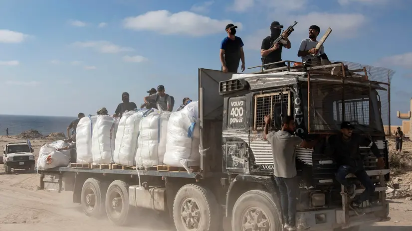 epa12197281 Palestinians from the clans secure aid trucks after they were allowed to enter humanitarian organizations in the Gaza Strip by the Israeli side, in the Zikim area west of Beit Lahia, northern Gaza Strip, 25 June 2025. EPA/HAITHAM IMAD