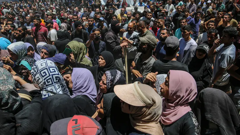 epa12198722 Displaced Palestinians wait to receive aid through the WFP after it successfully arrived at the organization’s warehouses in Gaza City, 26 June 2025. According to the UN half a million people, or one in five people in the Strip are facing starvation while the entire population of the Gaza Strip continues to face a critical risk of famine following 19 months of conflict, mass displacement and severe restrictions on humanitarian aid. EPA/MOHAMMED SABER