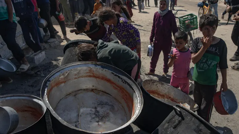 epa12144625 Internally displaced Palestinians gather outside a charity kitchen to receive limited rations amid a shortage of food, in Khan Younis, southern Gaza Strip, 30 May 2025. The United Nations has warned that "the entire population of Gaza is facing the risk of famine" since Israel closed border crossings on 02 March 2025, preventing the entry of essential supplies. The Gaza Government Media Office reported on 24 May that at least 58 people died due to malnutrition, and nearly 250 others due to a lack of food and medicine. EPA/HAITHAM IMAD
