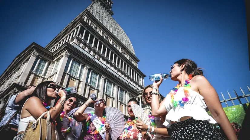 Alcune ragazze sotto la Mole Antonelliana in cerca di refrigerio per combattere le alte temperature dovute all'ondata di caldo estivo. Torino 28 giugno 2025 ANSA/TINO ROMANO