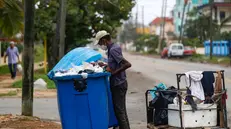 epa11076694 Eugenio, 72, searches through a garbage container on a street in Havana, Cuba, 10 January 2024 (issued 14 January 2024). Divers, locally known as 'buzos', searching through garbage tanks are an increasingly common sight in Havana and other Cuban cities, where three years of serious economic crisis are taking a dramatic social toll. EPA/YANDER ZAMORA