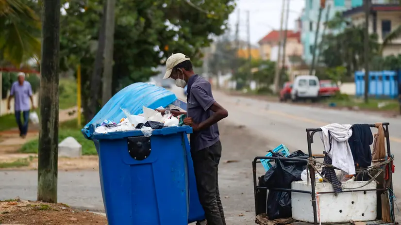 epa11076694 Eugenio, 72, searches through a garbage container on a street in Havana, Cuba, 10 January 2024 (issued 14 January 2024). Divers, locally known as 'buzos', searching through garbage tanks are an increasingly common sight in Havana and other Cuban cities, where three years of serious economic crisis are taking a dramatic social toll. EPA/YANDER ZAMORA
